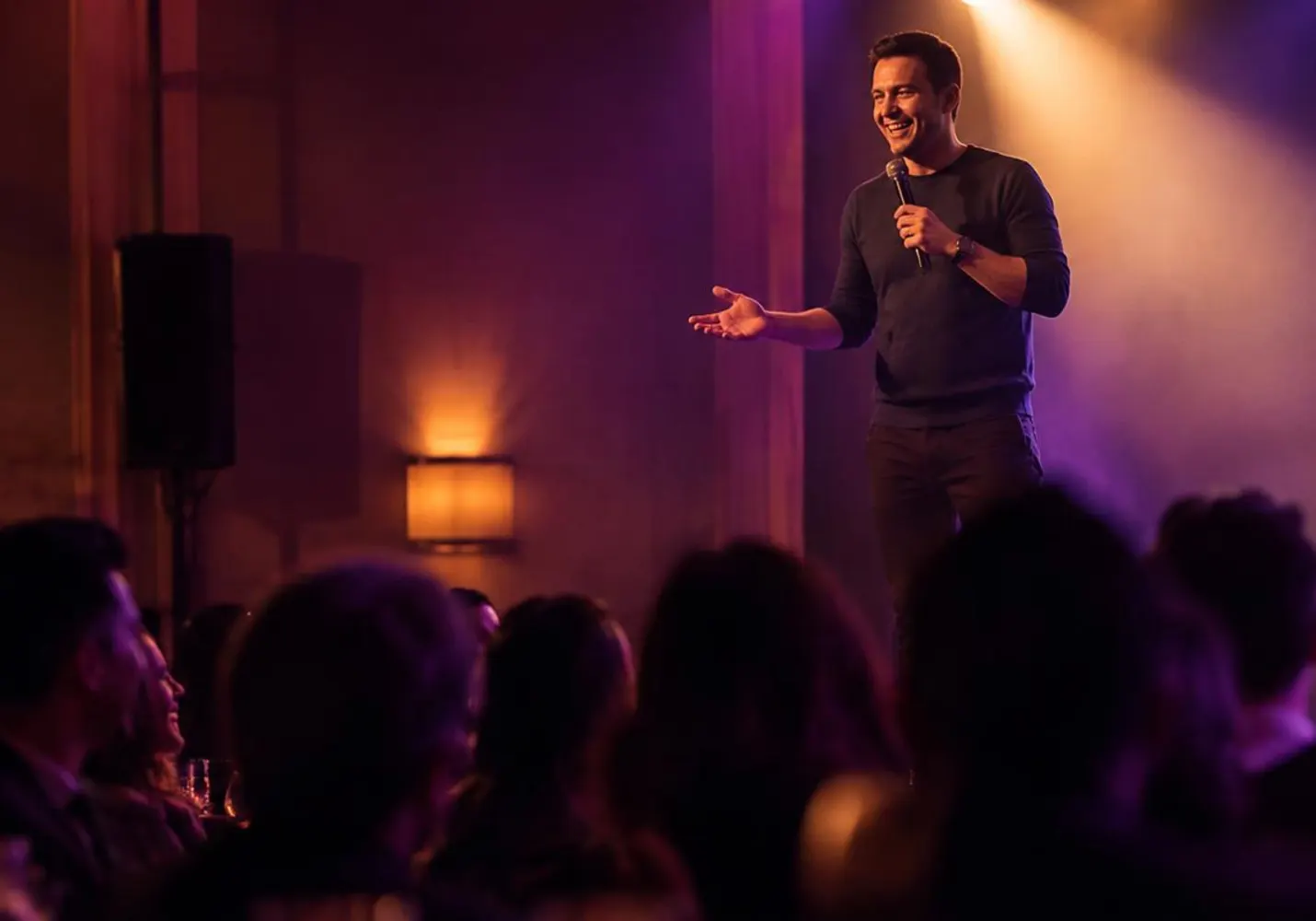 Comedian performing to a laughing crowd